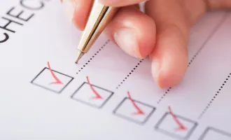 赤いボールペンでチェックしている画像